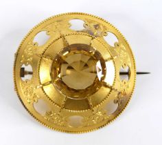A yellow metal Etruscan style target brooch, having a round faceted citrine claw set to the centre
