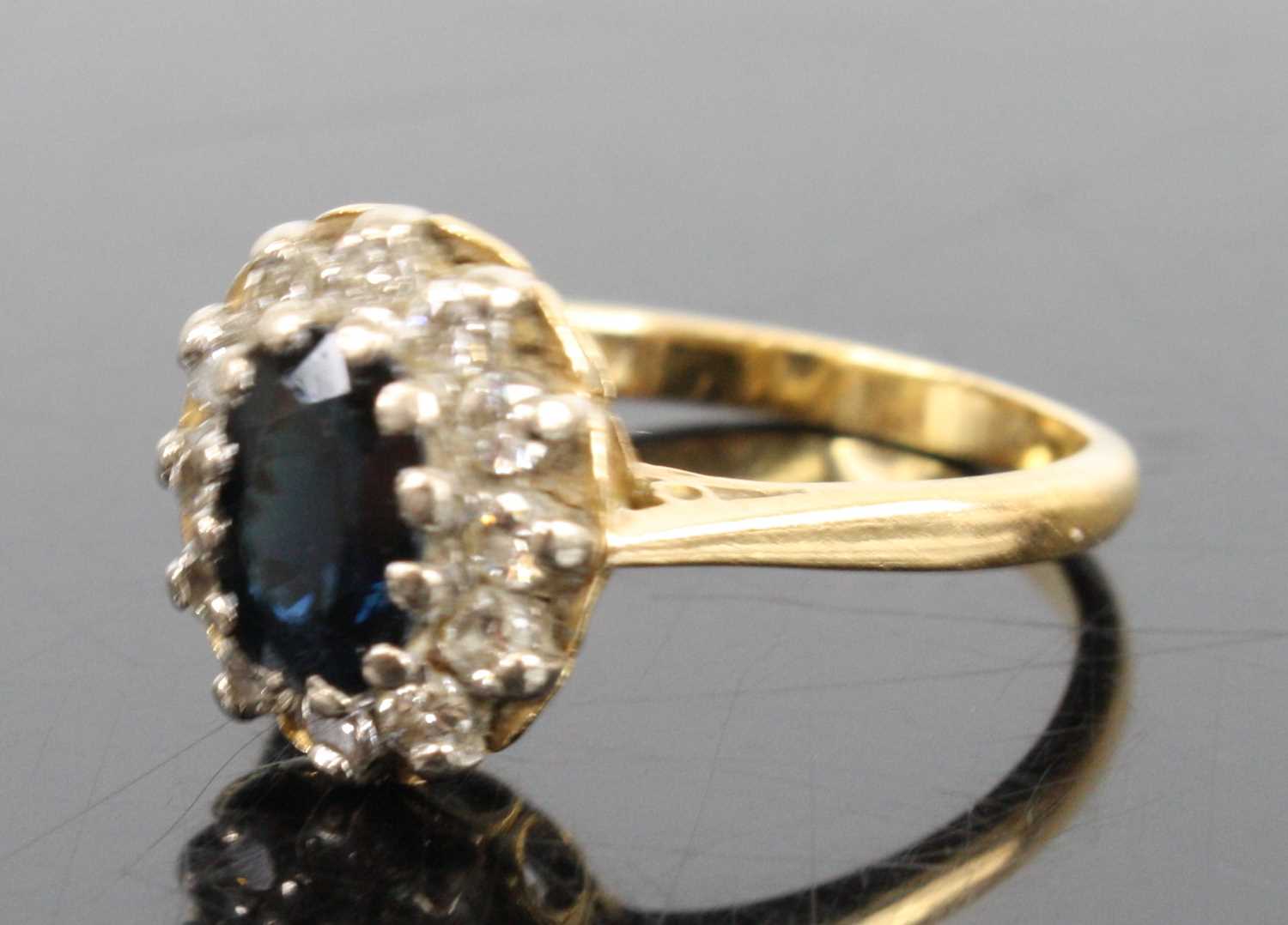 An 18ct yellow and white gold, sapphire and diamond oval cluster ring, featuring a centre oval - Image 2 of 3