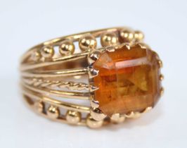 A yellow metal and citrine set dress ring, the emerald cut citrine measuring approx 11.7 x 9.4 x 7.