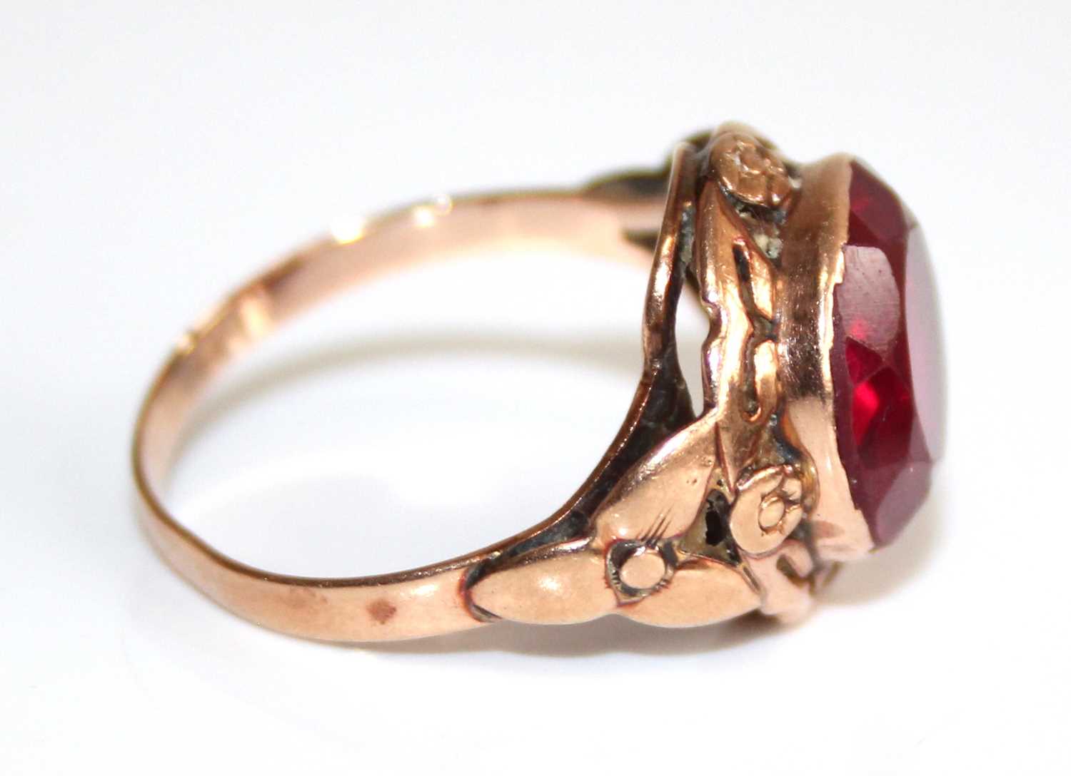 A yellow metal and synthetic ruby set dress ring, the large round cut red stone measuring approx - Image 2 of 6