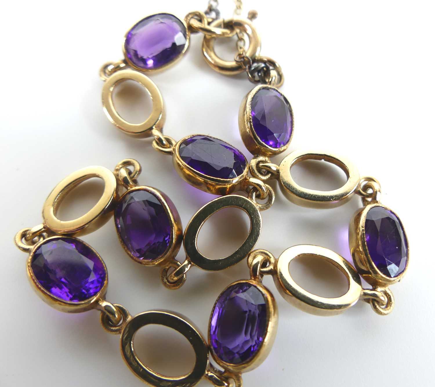 A 9ct yellow gold amethyst bracelet, featuring seven oval amethysts alternating with open oval - Image 3 of 4