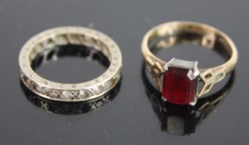 A 9ct gold and silver set garnet dress ring, size M; together with a white metal and cz set eternity