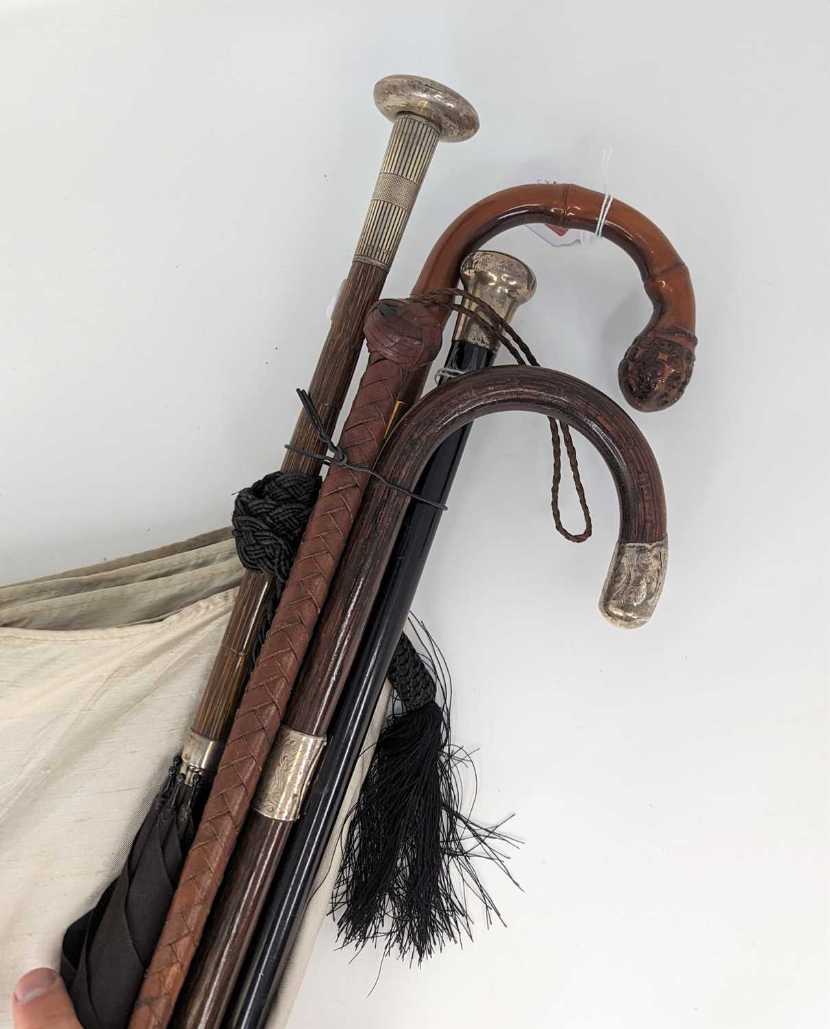 A Victorian ebonised wooden walking stick, having a silver top, length 91cm; together with a stained