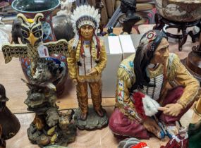 A modern resin figure of a native American man, shown seated, height 44cm, together with two