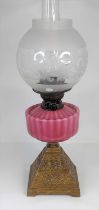 A Victorian oil lamp, having a pink glass font and acid etched clear glass shade, height 57cm