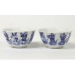 A pair of Chinese blue & white glazed porcelain teabowls, each underglaze decorated with figures,