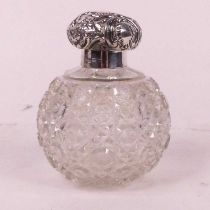 A Victorian silver lidded cut glass scent bottle, the lid repousse decorated with flowers, marks