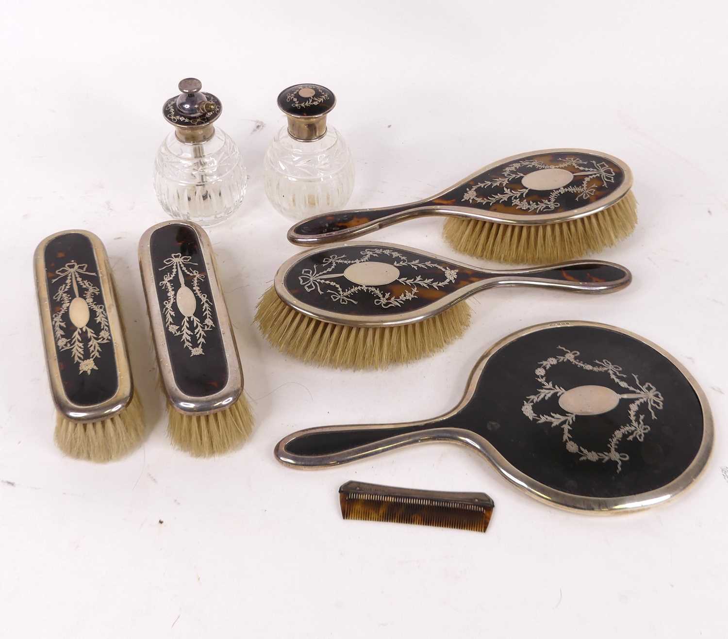 A George V silver clad tortoiseshell and piquet worked dressing table brush set comprising two