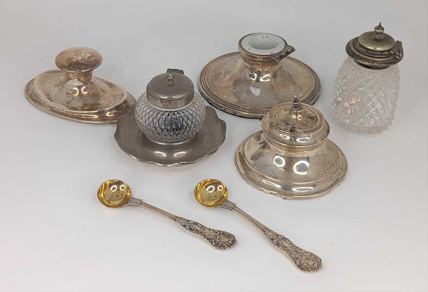 A George V silver capstan inkwell of shaped oval form on a weighted base together with various other