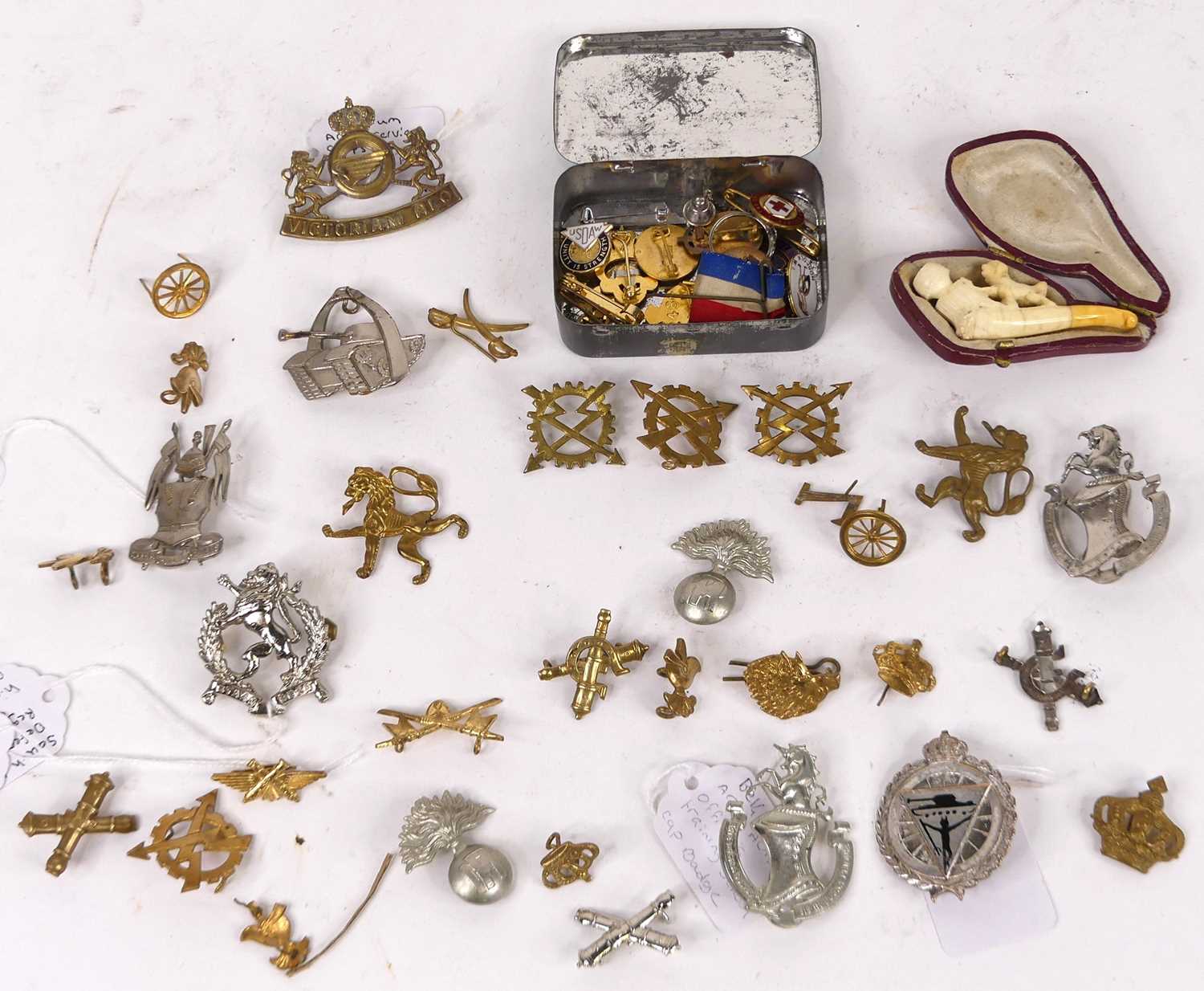 A collection of military cap badges, to include South Africa Defence Force and Belgian Anti-Aircraft