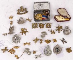 A collection of military cap badges, to include South Africa Defence Force and Belgian Anti-Aircraft