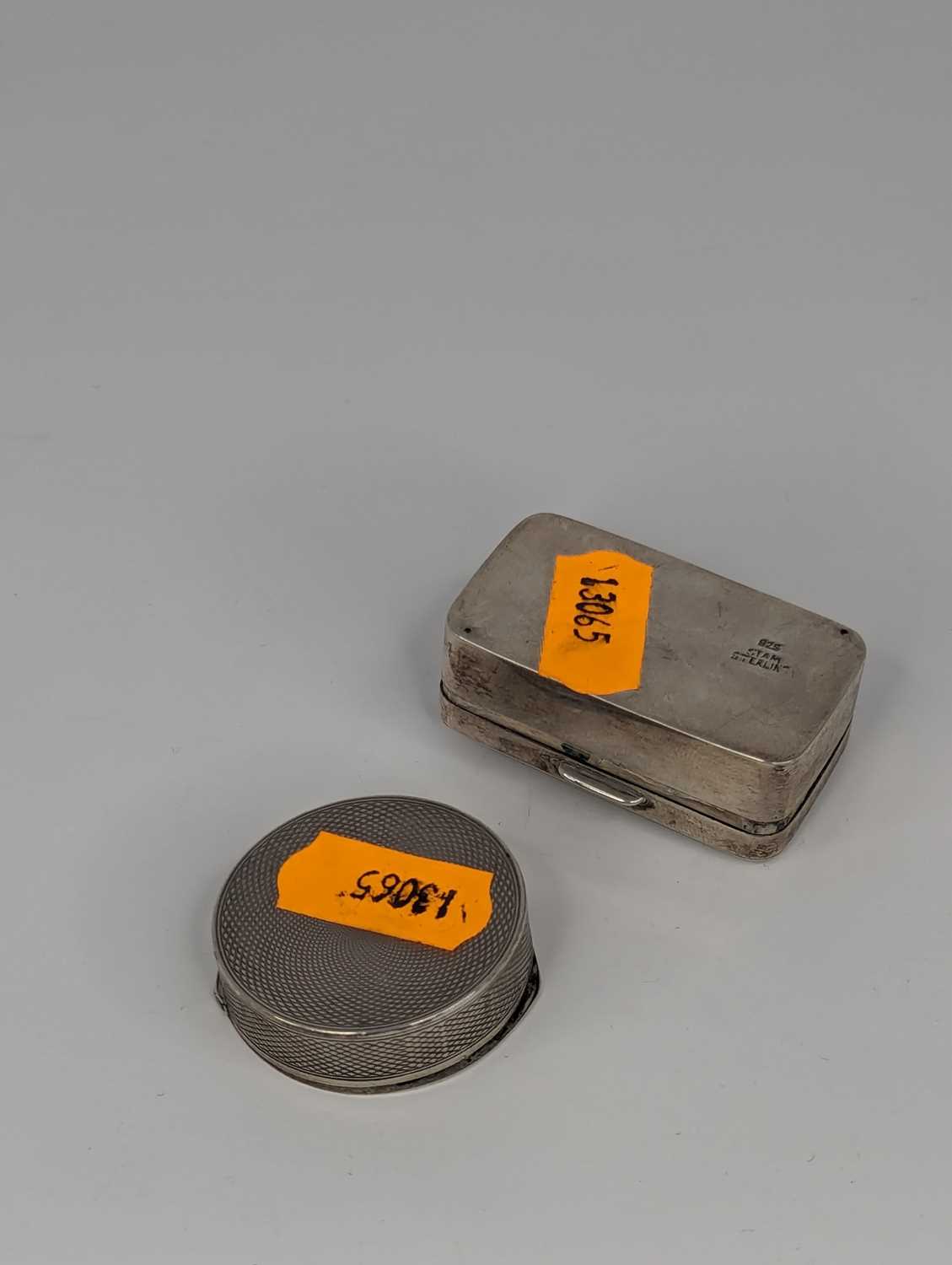 A white metal pill box of hinged rectangular form, the cover repoussee decorated with a figure of - Image 2 of 2