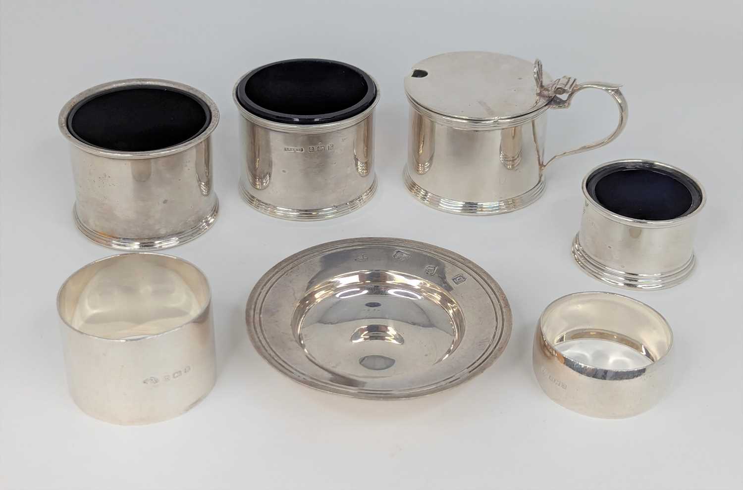 A George V silver mustard of cylindrical form having pierced raised thumb piece and blue glass