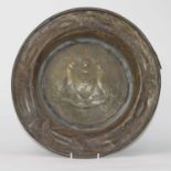 A Glasgow School Arts & Crafts copper charger, the sunken well repoussee decorated with a coat of