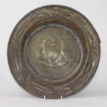 A Glasgow School Arts & Crafts copper charger, the sunken well repoussee decorated with a coat of