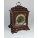 An early 20th century walnut bracket clock, the chapter ring showing Roman numerals with brass