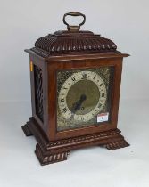 An early 20th century walnut bracket clock, the chapter ring showing Roman numerals with brass
