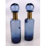 A pair of blue glass bottles, each having a brass collar, height 41cm