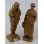 A pair of continental carved pine figures of a lady and gentleman, each shown standing, height 29cm