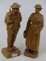A pair of continental carved pine figures of a lady and gentleman, each shown standing, height 29cm