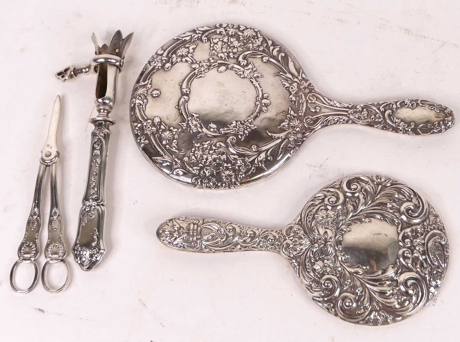 A collection of metalware, to include two repousse decorated silver dressing table hand mirrors, a