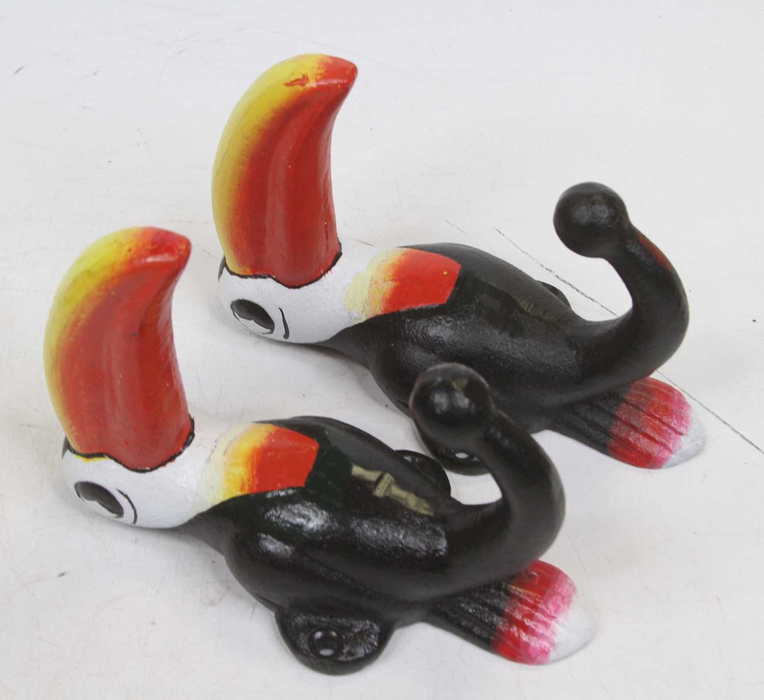 A pair of painted metal coat hooks, each in the form of a Guinness Toucan