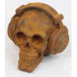 A rusted metal model of a skull wearing headphones, h.12cm