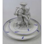 A Meissen blanc de chine porcelain candlestick, in the form of a seated putti before a tree trunk,