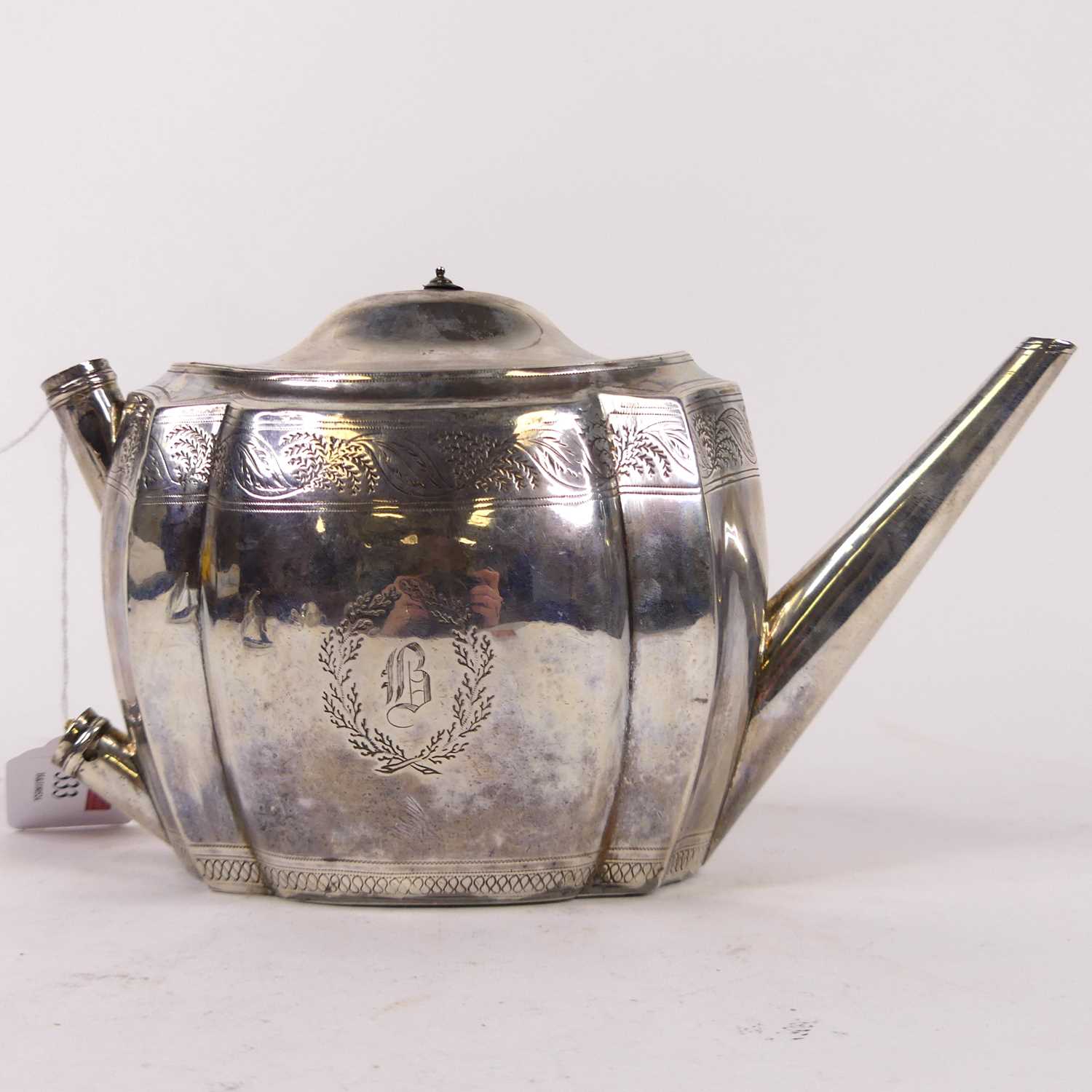 A George III Scottish silver teapot, of shaped oval form, bright cut engraved with bands of