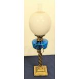 A Victorian brass oil lamp, having a blue glass font and milk glass shade, height 68cm
