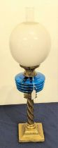 A Victorian brass oil lamp, having a blue glass font and milk glass shade, height 68cm