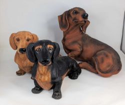 Three modern resin models of dachshunds, largest height 30cm