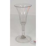 An 18th century wine glass having a trumpet shaped bowl on plain stem and domed foot with folded