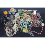 Exotic costume jewellery to include rolled gold bangle, beaded necklaces, brooches, etc