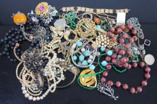 Exotic costume jewellery to include rolled gold bangle, beaded necklaces, brooches, etc