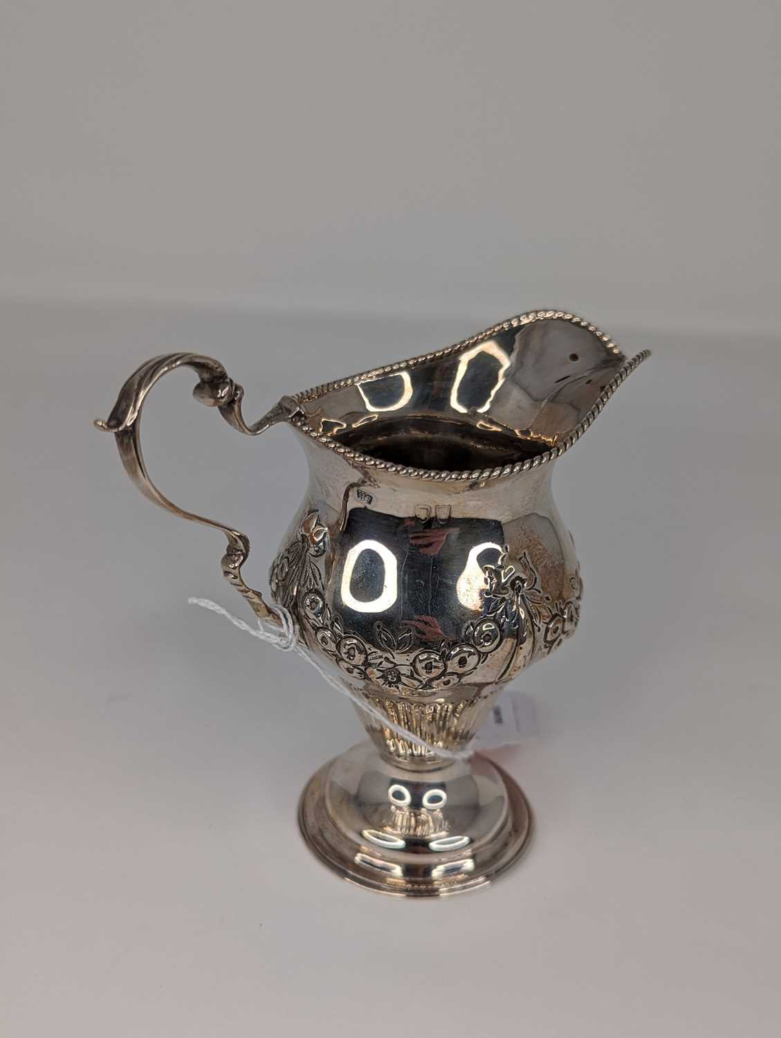 A Victorian silver cream jug, having a beaded rim, to a bellied body, repoussee decorated with - Image 2 of 2