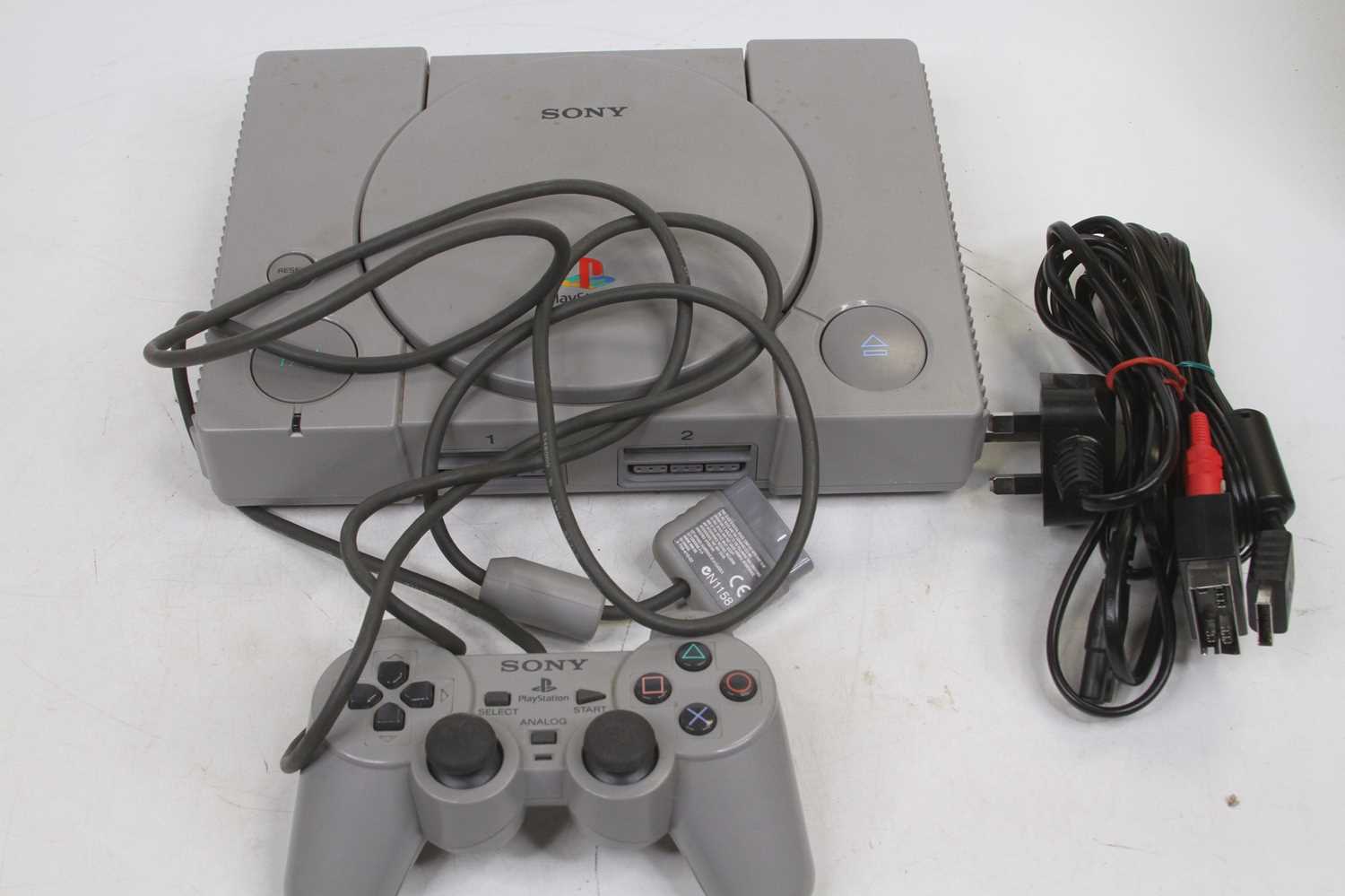 A Sony Playstation console, with controller, power cord, and scart lead