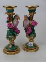 A pair of ornate gilt painted and simulated malachite candle stands, each decorated with a parrot