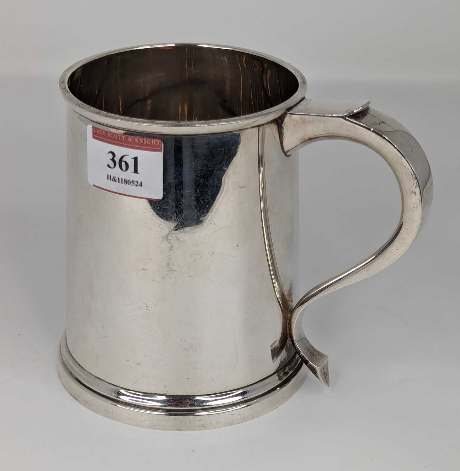 An Elizabeth II silver tankard of plain tapered cylindrical form with C-scroll handle, weight 10.