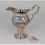 A Victorian silver cream jug, having a beaded rim, to a bellied body, repoussee decorated with