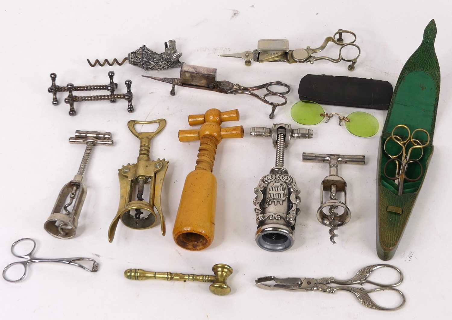 A collection of corkscrews together with a brass gavel, wick scissors, and cased spectacles