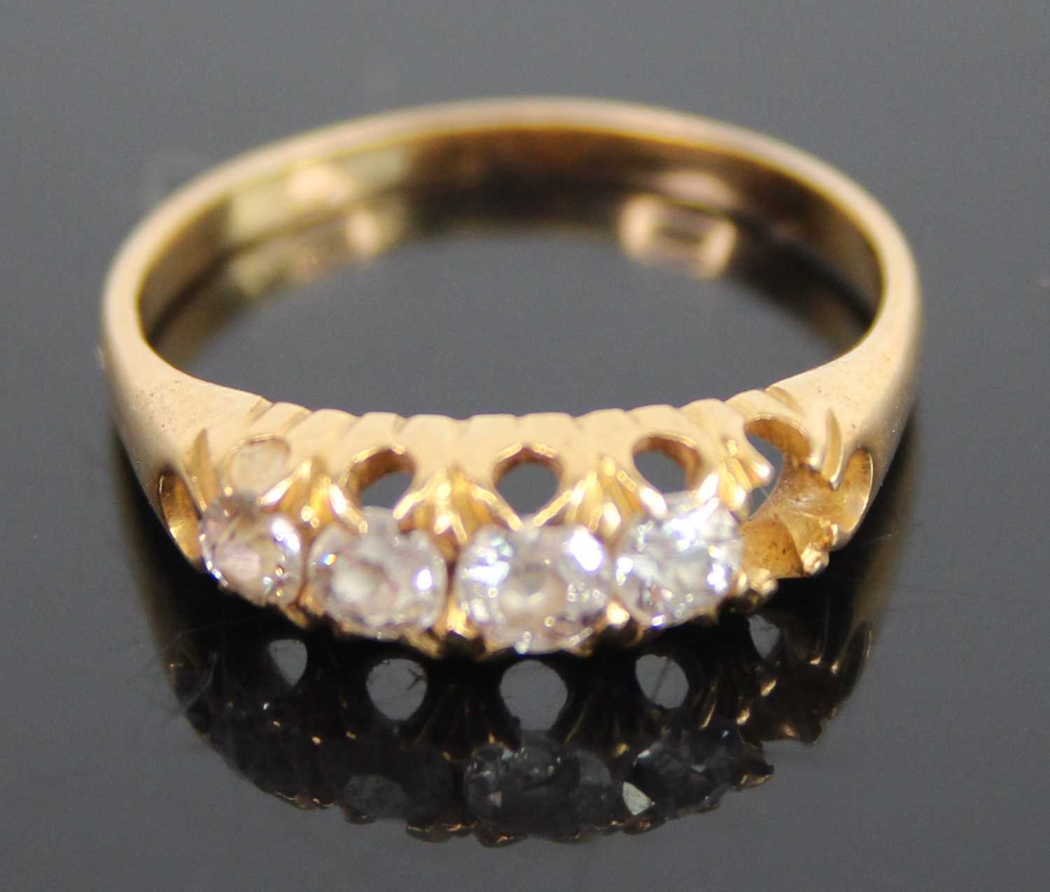 An 18ct gold diamond half hoop ring, arranged as five graduated old round cuts (one outer stone