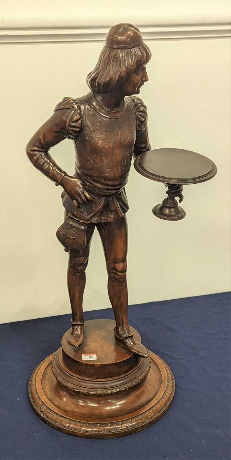 A carved walnut figure of a young man shown in 17th century dress, mounted upon a carved swivel
