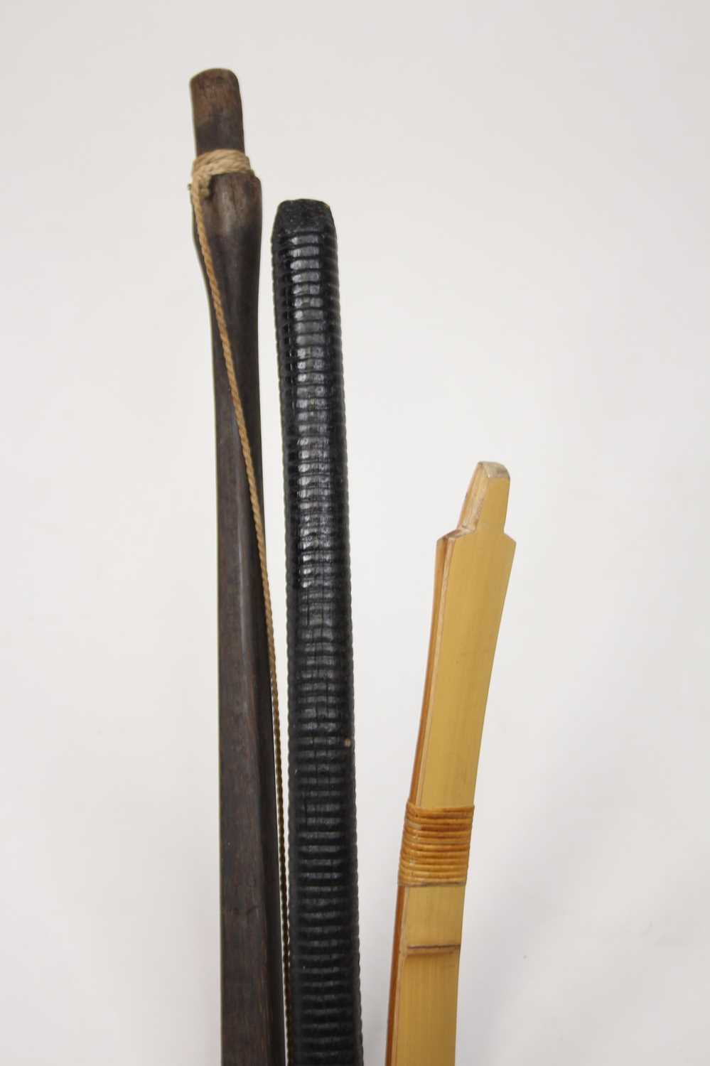 An Asian bent bamboo long bow, length 219cm, together with a hardwood example, and a hardwood