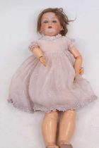An early 20th century Armand Marseille bisque headed doll, having rolling eyes and showing four