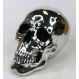 A silver painted composite model of a skull