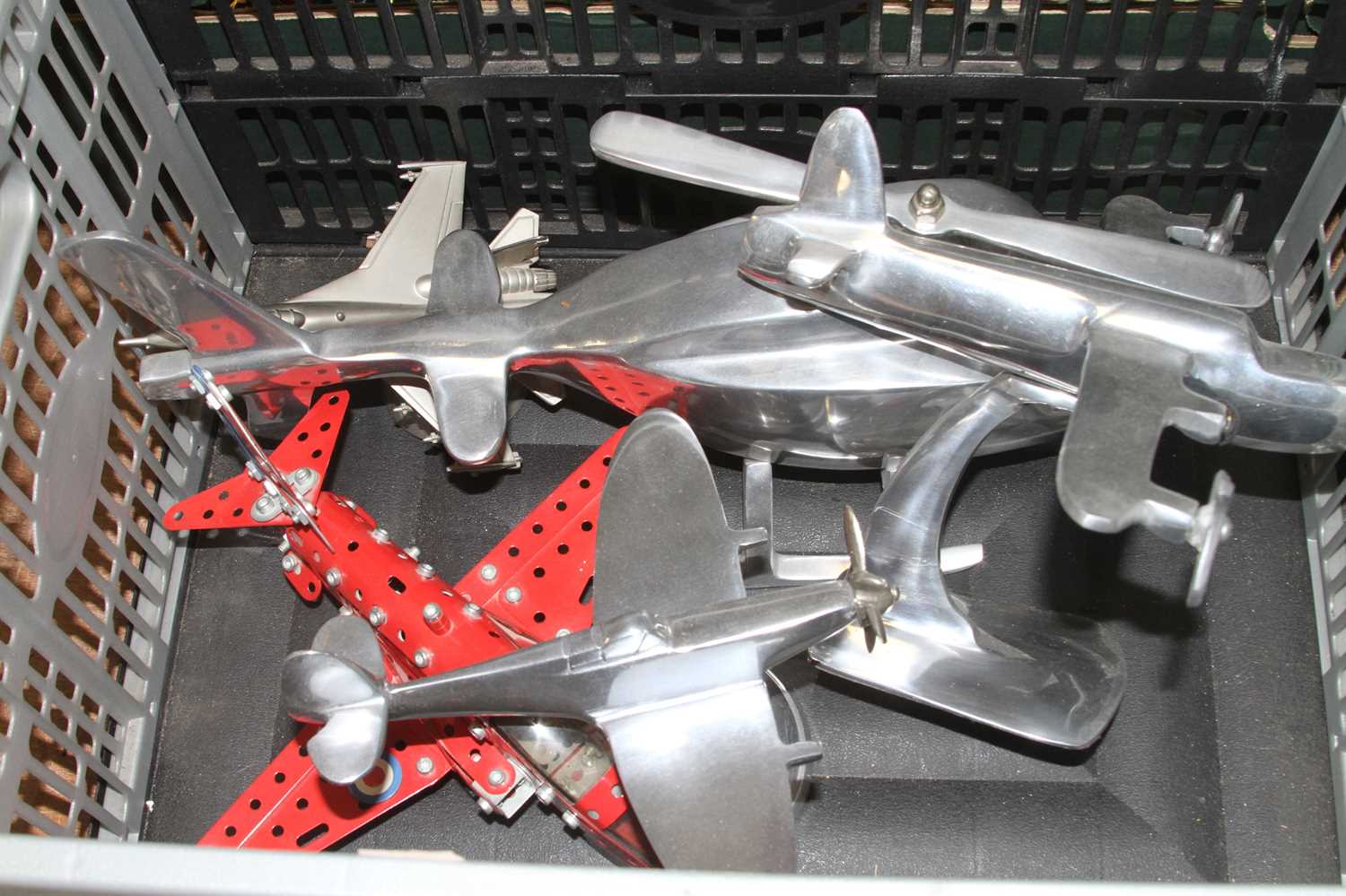 A polished aluminium model of a helicopter, length 38cm, together with four model aeroplanes