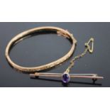 A 9ct gold and engraved hinge bangle 4.9g, dia. 6.4cm, together with a 9ct gold amethyst bar brooch,