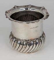 A late Victorian silver bowl, having a shaped rim to a cylindrical body and wrythen moulded base,