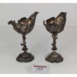 A pair of late 19th century continental white metal open salts, each having an embossed shell shaped